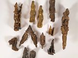 de nombreuses petites figurines en bronze posées sur une surface blanche