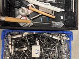 de nombreux outils dans une boîte en plastique posée par terre