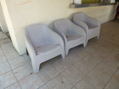 trois chaises placées les unes à côté des autres sur un sol carrelé