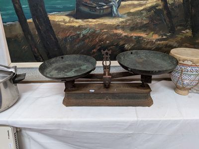une photo d'un tableau posé sur une table sur laquelle se trouve une balance