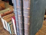 three old books are stacked on top of each other on a table