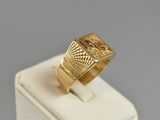 a close up of a gold ring on top of a white stand