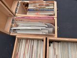 a lot of records in a wooden box on the floor