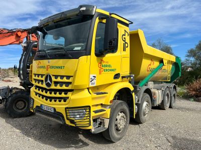 un gros camion jaune garé sur le bord de la route