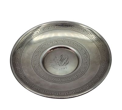 a silver plate with a design on it on a white background