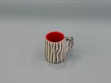 un gobelet rouge posé sur une table blanche