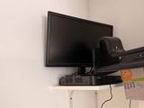a television on a shelf in the corner of a room