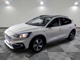 la voiture blanche est garée sur un sol en damier dans le garage