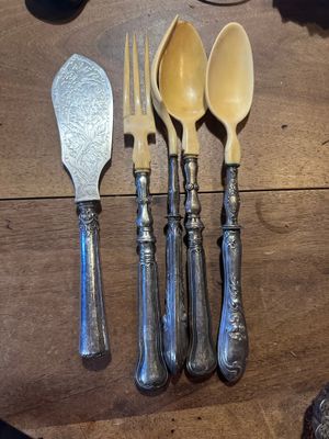 quatre cuillères, une fourchette et une cuillère sur une table
