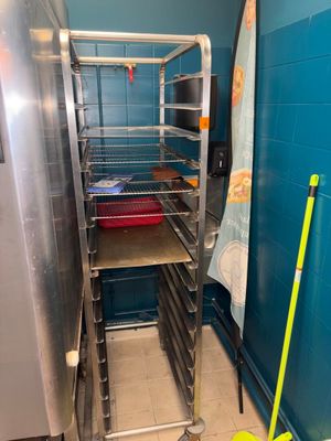 une photo d'une cuisine avec un étagère remplie de provisions et une serpillière