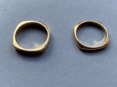 deux bagues en or posées l'une sur l'autre sur une table