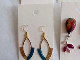 four pairs of earrings are displayed on a card with a price tag