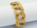 a close up of a gold rope bracelet on a napkin