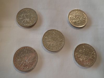quatre types de pièces différents posés sur une surface blanche
