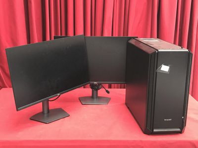 deux écrans d'ordinateur posés sur une table recouverte d'une nappe rouge