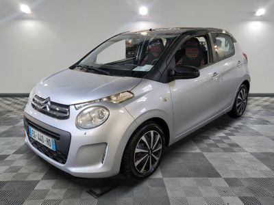 la photo d'une petite voiture argentée sur un sol en damier