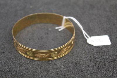 a close up of a gold bracelet with a tag on it