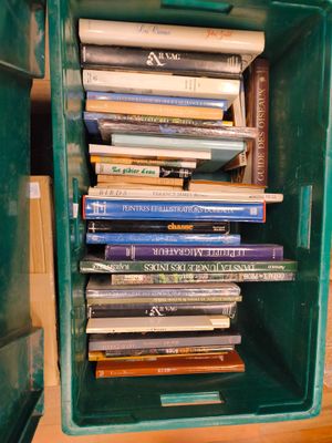 une boîte verte remplie de livres posée sur une table en bois