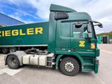 a large green truck parked in front of a building