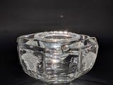 an image of a clear glass ashtray on a black background