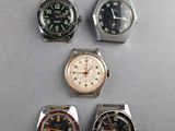 four different types of watches are displayed on a table