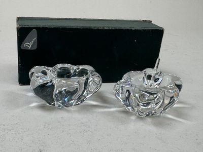 une paire de bougeoirs en verre transparent, avec une boîte noire en arrière-plan