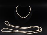 un ensemble composé d'un collier et d'un bracelet en perles blanches sur fond noir