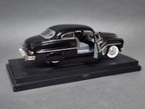 a black model of a classic car on a black base