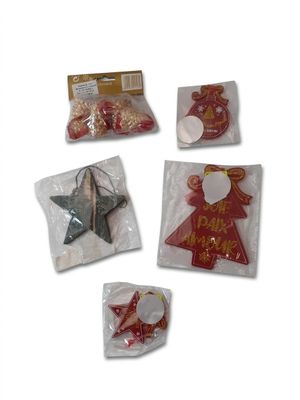 cinq décorations de Noël dans des sacs en plastique posées sur une surface blanche