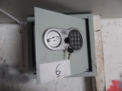 un coffre-fort en métal muni d'une clé et d'une étiquette