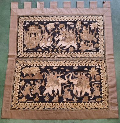 a close up of a black and gold rug on a green floor