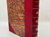 an old book with a red cover and a gold and red design