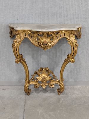 an antique console table with a marble top and gold leaf decoration