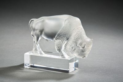 a glass figurine of a buffalo on a clear base