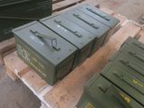 trois cartons verts posés sur une palette, elle-même posée sur une autre palette