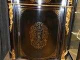 un meuble noir et doré avec un plateau en marbre