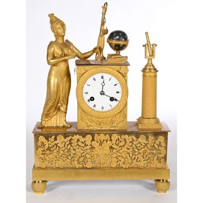 a gold clock with a statue on top of it