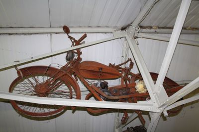 an old motorcycle hanging from the ceiling of a garage