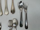 a lot of silver spoons and forks on the table