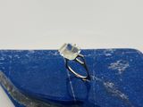 un gros plan sur une pierre bleue sur laquelle repose une bague