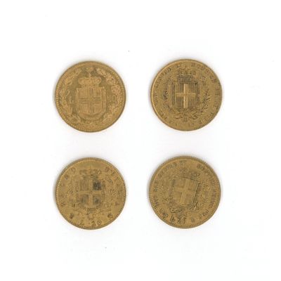 quatre types différents de pièces d'or sur une surface blanche