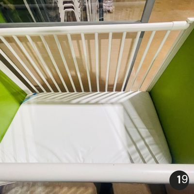 un lit de bébé blanc recouvert d'un drap blanc