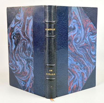 un vieux livre à la couverture bleue, orné d'un motif rouge et bleu