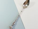 silver spoon on a blue and white background with a silver handle