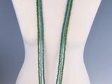 un mannequin blanc orné de perles vertes et d'un collier