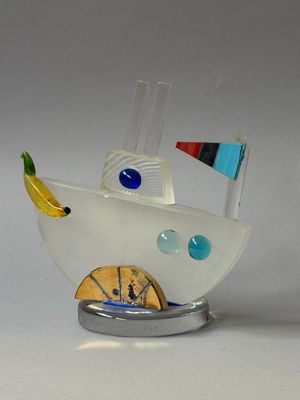 une sculpture en verre représentant un bateau surmonté d'une banane