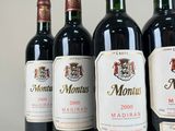 six bottles of red wine are lined up in a row