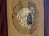 painting of a man in a turban in a frame on a wall