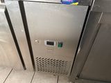 a stainless steel freezer in the corner of a kitchen