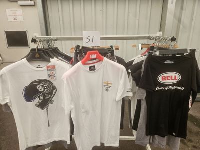 several t - shirts are hanging on a rack in a garage